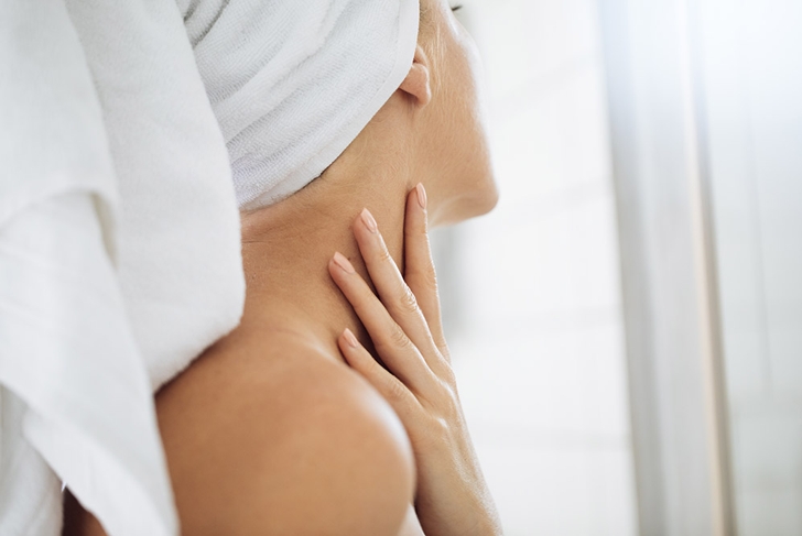 woman touching neck skincare